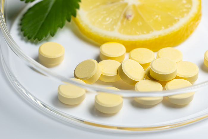 Lemon with Vitamin Supplement White Background