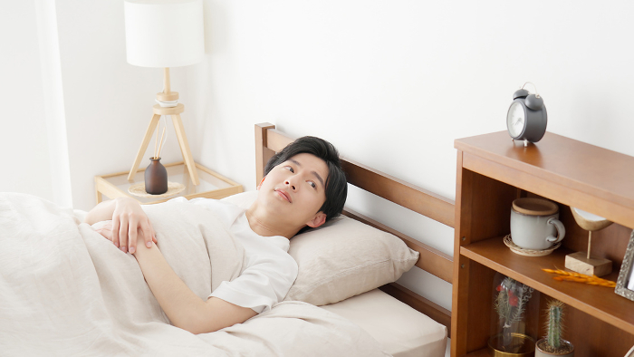 Japanese man waking up with alarm clock (People)