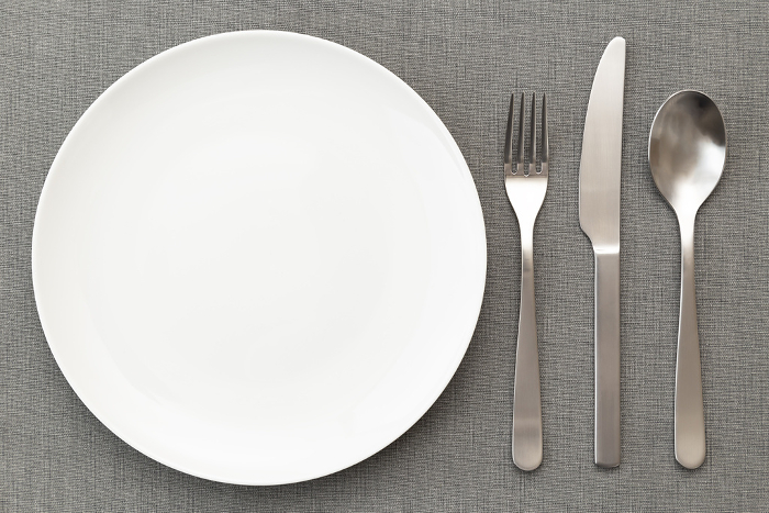 Luncheon mat, white plate and cutlery