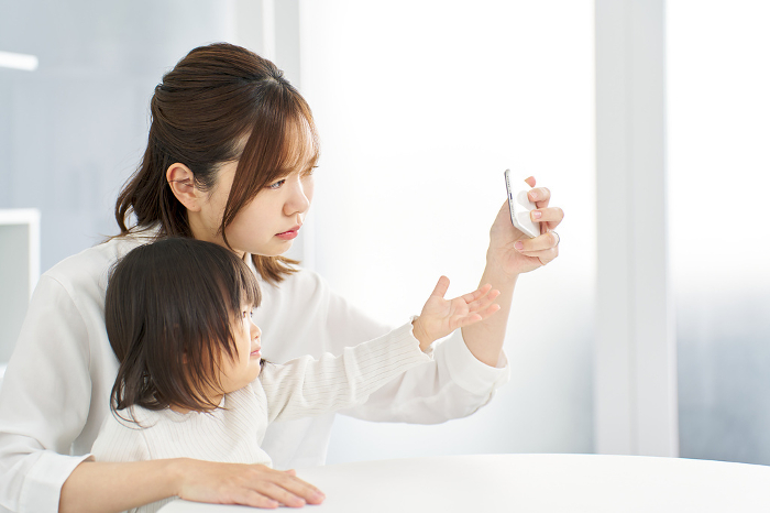 A Japanese mother takes her phone away from her child.