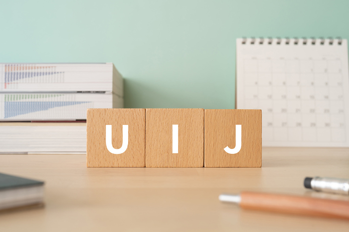 Desk with a block with the letters UIJ on it.
