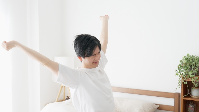 Japanese man stretching after waking up (People)
