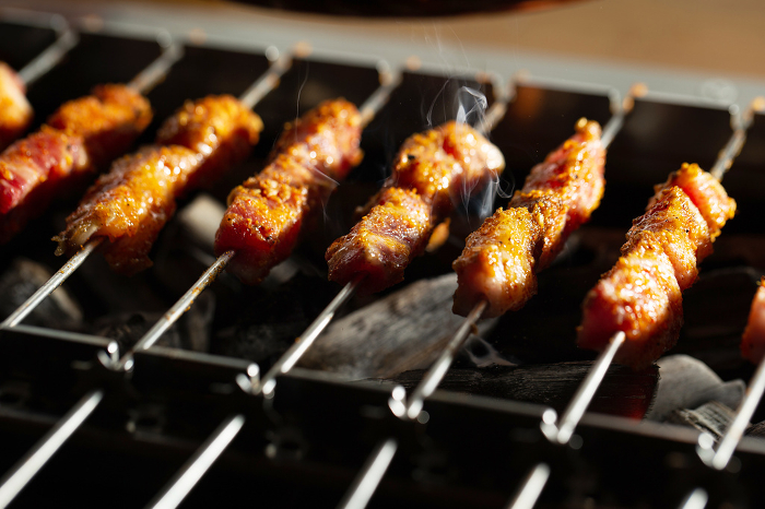 Grilled lamb skewers over charcoal