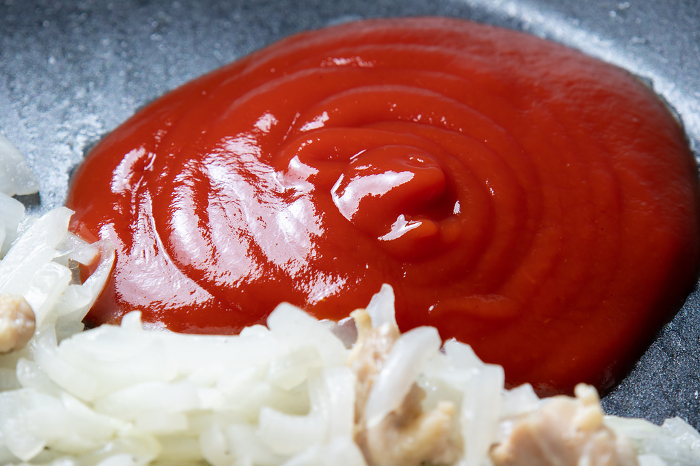 Close-up of the cooking scene (chicken rice cooking scene) where ketchup is added to the pan.