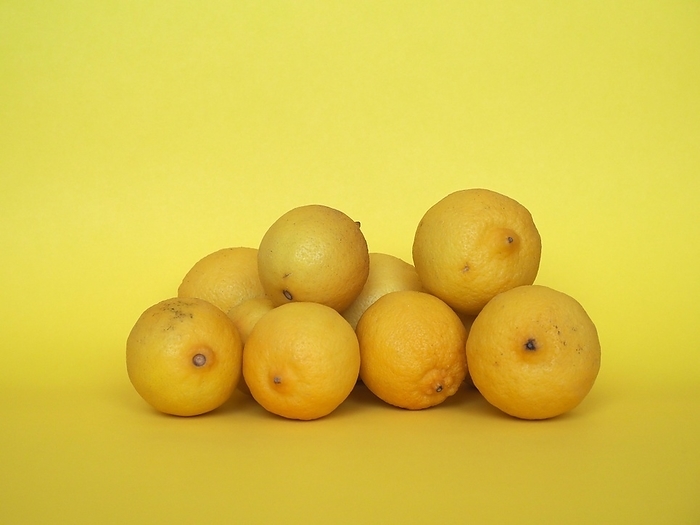 Lemon fruits over yellow background, by Claudio Divizia