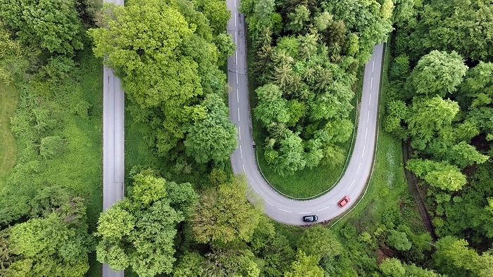 A red and a black car driving on a serpentine road through a green landscape, drone shot, Upper Bavaria, Bavaria, Germany, Europe, by Gerhard Nixdorf