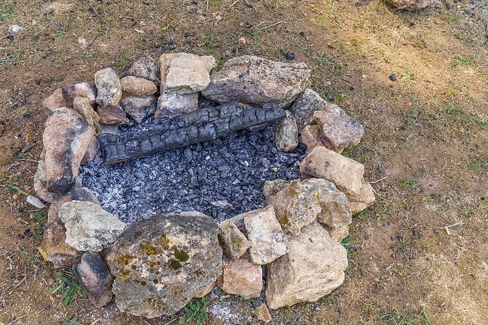 Fire extinguished in the field with stones around it, concept cause of fire, by joseantona