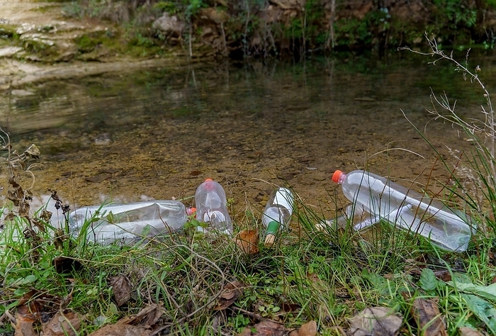 Bank of a mountain river full of plastic bottles, concept of ecology and conservation of the environment, by joseantona