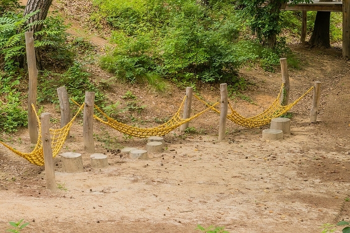 Yellow rope bridge hanging between wood posts, part of exercise and obstacle course in public park, South Korea, South Korea, Asia, by aminkorea