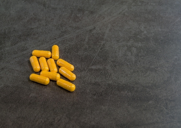 Vitamin B tablets isolated on black textured background, by aminkorea