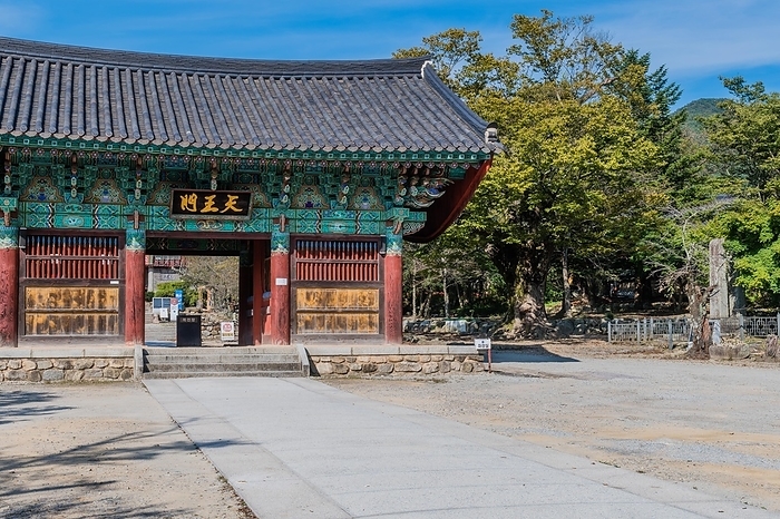 Building with ceramic tiled roof at entrance to Geumsansa temple under blue sky in Gimje-si, South Korea, Asia, by aminkorea