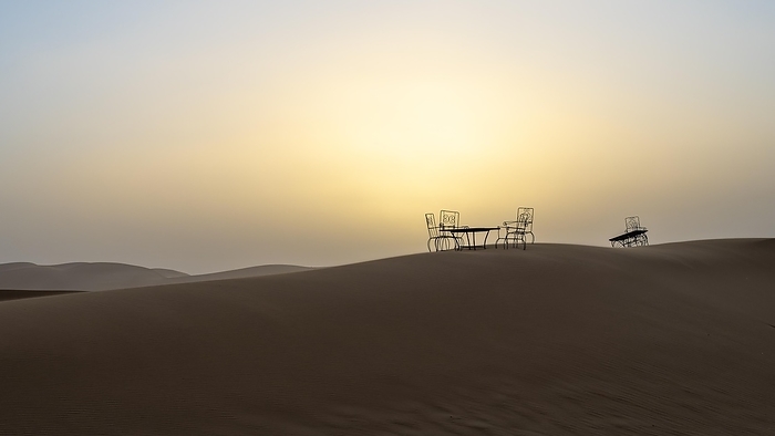 Sunset, cast iron table and chairs in the sand dunes of Erg Chebbi, Sahara, Merzouga, Morocco, Africa, by Sonja Jordan