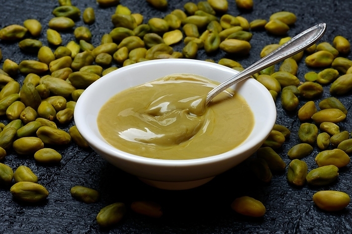 Pistachio cream in small bowls with spoon, pistachios, by Jürgen Pfeiffer