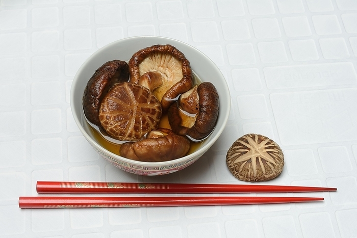 Dried shiitake mushrooms in a bowl, soaked in water, by Jürgen Pfeiffer