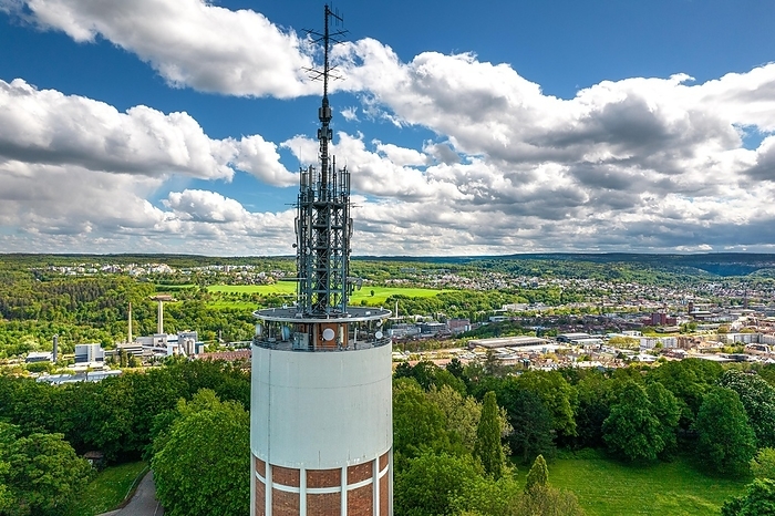 Radio tower rises above green landscape with city view and blue sky in the background, new water tower, Pforzheim, Germany, Europe, by Manuel Kamuf