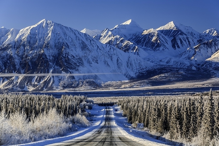 Highway in winter landscape in front of snow-covered mountains, Alaska Highway, Haines Junction, Yukon Territory, Canada, North America, by Martina Melzer