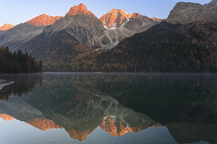Mountains reflected in a mountain lake at sunrise, autumn, Lake Antholz, Rieserferner Group, South Tyrol, Italy, Europe, by Martina Melzer