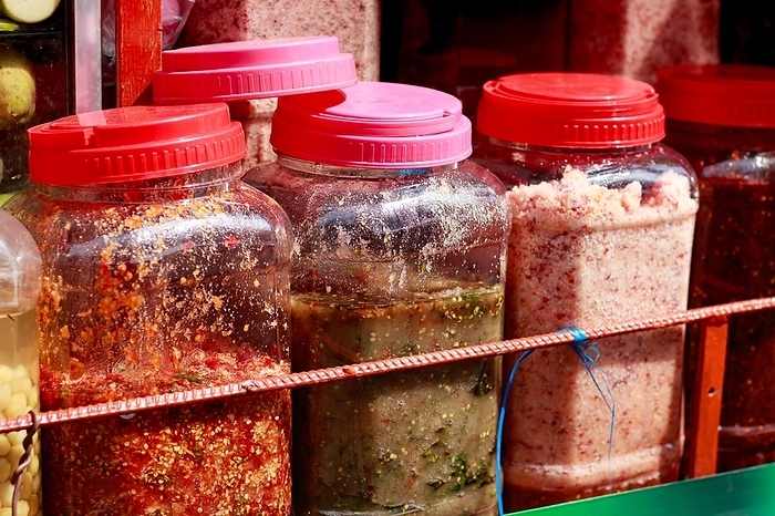 Rows of assorted authentic traditional khmer crack sauces called Chrouk Metae or chili paste, prahok or fermented fish paste and Tuk trey or fish paste sold in the local market of Kampot, Cambodia, Asia, by MartinxMarie
