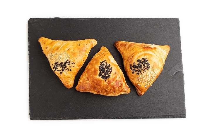 Homemade asian pastry samosa on black slate board isolated on white background. top view, flat lay, close up, by ULADZIMIR ZGURSKI