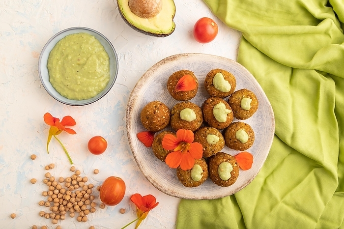 Falafel with guacamole on white concrete background and green linen textile. Top view, flat lay, close up, by ULADZIMIR ZGURSKI