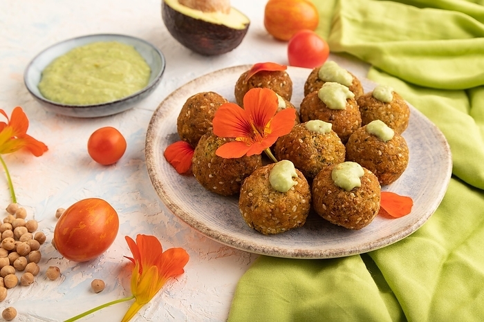 Falafel with guacamole on white concrete background and green linen textile. Side view, close up, by ULADZIMIR ZGURSKI