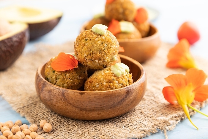 Falafel with guacamole on blue wooden background and linen textile. Side view, close up, selective focus, by ULADZIMIR ZGURSKI