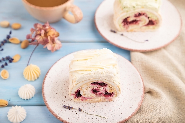 Roll biscuit cake with cream cheese and jam, cup of coffee on blue wooden background and linen textile. side view, close up, selective focus, by ULADZIMIR ZGURSKI