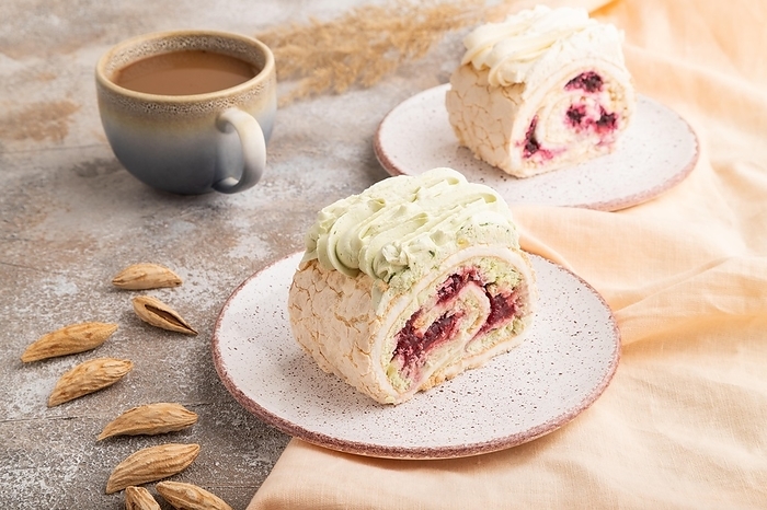 Roll biscuit cake with cream cheese and jam, cup of coffee on brown concrete background and orange linen textile. side view, close up, by ULADZIMIR ZGURSKI
