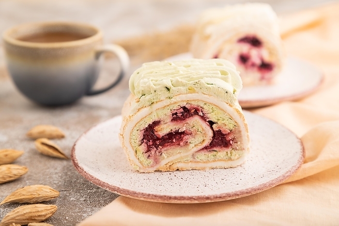 Roll biscuit cake with cream cheese and jam, cup of coffee on brown concrete background and orange linen textile. side view, close up, selective focus, by ULADZIMIR ZGURSKI