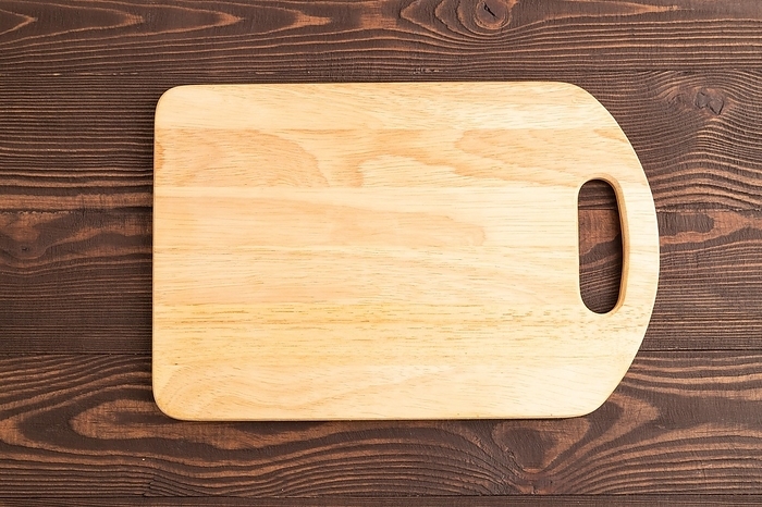 Empty rectangular wooden cutting board on brown wooden background. Top view, close up, flat lay, by ULADZIMIR ZGURSKI