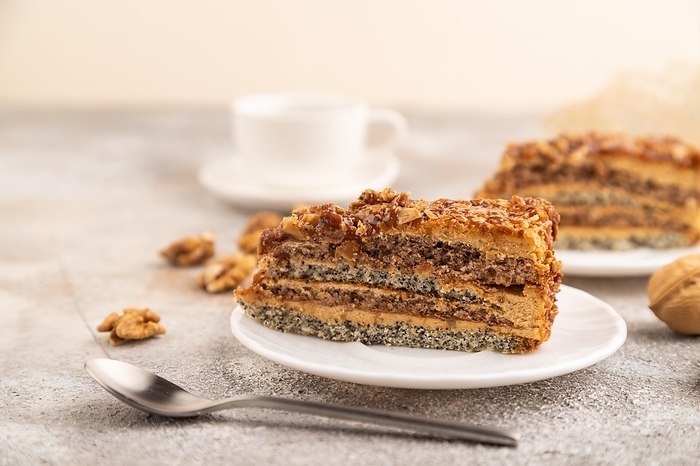 Walnut and hazelnut cake with caramel cream, cup of coffee on brown concrete background. side view, selective focus, by ULADZIMIR ZGURSKI