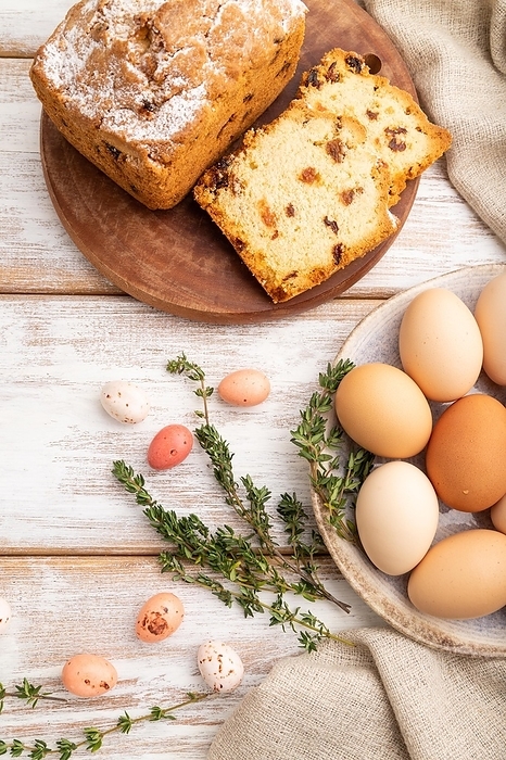Homemade easter pie with raisins and eggs on plate on a white wooden background and linen textile. top view, flat lay, close up, by ULADZIMIR ZGURSKI