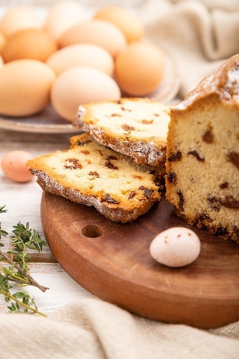 Homemade easter pie with raisins and eggs on plate on a white wooden background and linen textile. side view, close up, selective focus, by ULADZIMIR ZGURSKI