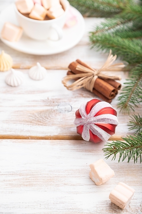 Christmas or New Year composition. Decorations, box, balls, cinnamon, fir and spruce branches, cup of coffee, on a white wooden background. Side view, copy space, selective focus, by ULADZIMIR ZGURSKI