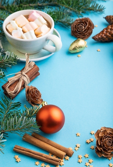Christmas or New Year composition. Decorations, box, cinnamon, cones, fir and spruce branches, cup of coffee, on a blue paper background. Side view, copy space, by ULADZIMIR ZGURSKI
