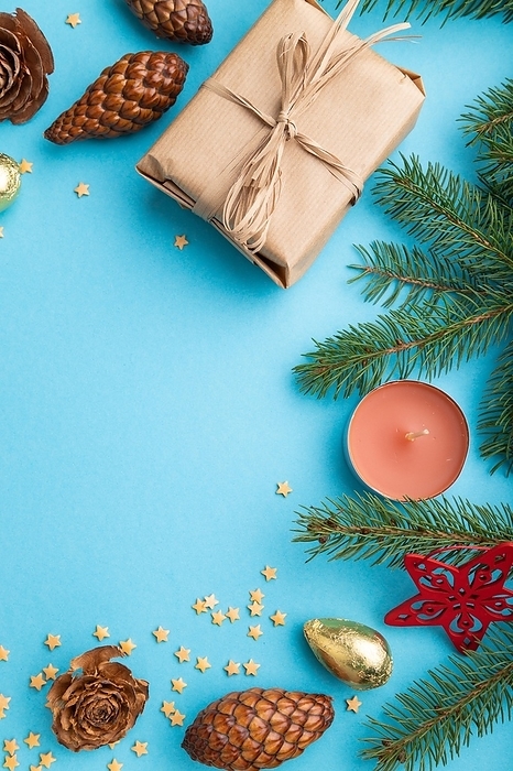 Christmas or New Year composition. Decorations, box, cinnamon, cones, fir and spruce branches, cup of coffee, on a blue paper background. Top view, copy space, flat lay, by ULADZIMIR ZGURSKI