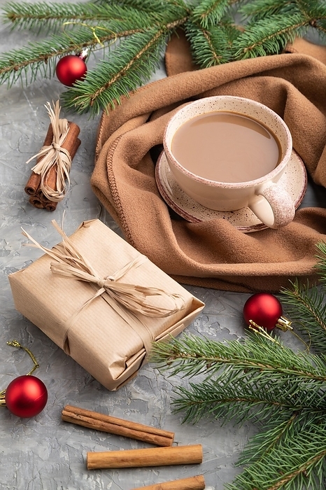 Christmas or New Year composition. Decorations, box, cinnamon, fir and spruce branches, cup of coffee, wool scarf on a gray concrete background. Side view, close up, by ULADZIMIR ZGURSKI