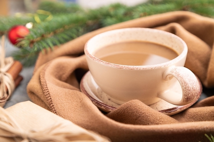 Christmas or New Year composition. Decorations, box, cinnamon, fir and spruce branches, cup of coffee, wool scarf on a gray concrete background. Side view, close up, selective focus, by ULADZIMIR ZGURSKI