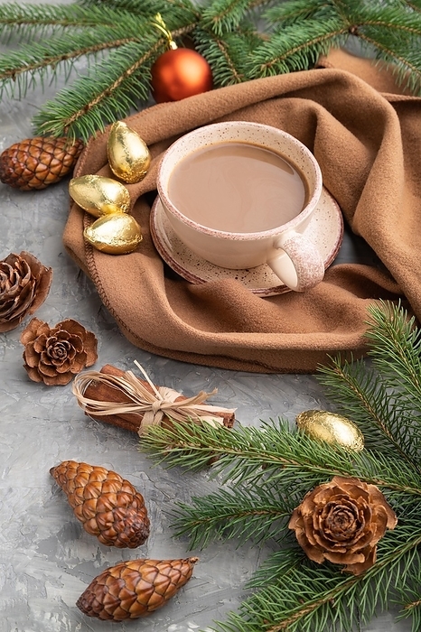 Christmas or New Year composition. Decorations, cones, cinnamon, fir and spruce branches, cup of coffee, wool scarf on a gray concrete background. Side view, close up, by ULADZIMIR ZGURSKI