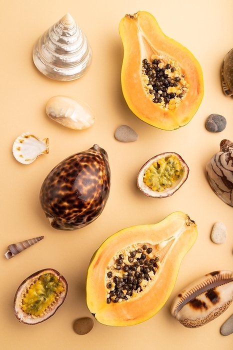 Ripe cut papaya, passion fruit, seashells, pebbles on orange pastel background. Top view, flat lay, close up. Tropical, healthy food, vacation, holidays concept, by ULADZIMIR ZGURSKI