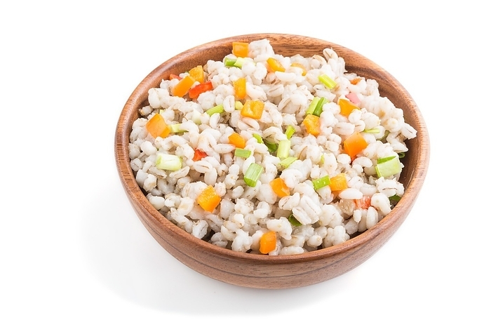Pearl barley porridge with vegetables in wooden bowl isolated on white background. Side view, close up. Russian traditional cuisine, by ULADZIMIR ZGURSKI