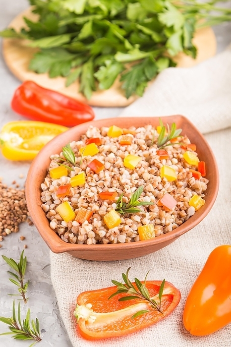 Buckwheat porridge with vegetables in clay bowl on a gray concrete background and linen textile. Side view, selective focus, close up. Russian traditional cuisine, by ULADZIMIR ZGURSKI