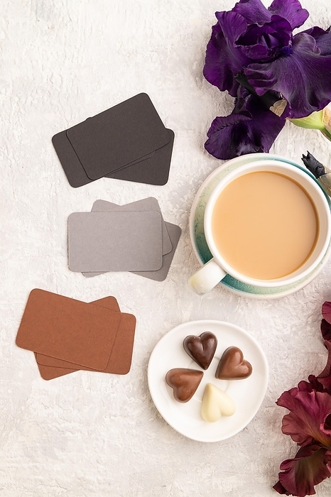 Set of gray, black, brown business cards with cup of cioffee, chocolate candies, purple and burgundy iris flowers on gray concrete background. top view, flat lay, copy space, still life. Breakfast, morning, spring concept, by ULADZIMIR ZGURSKI