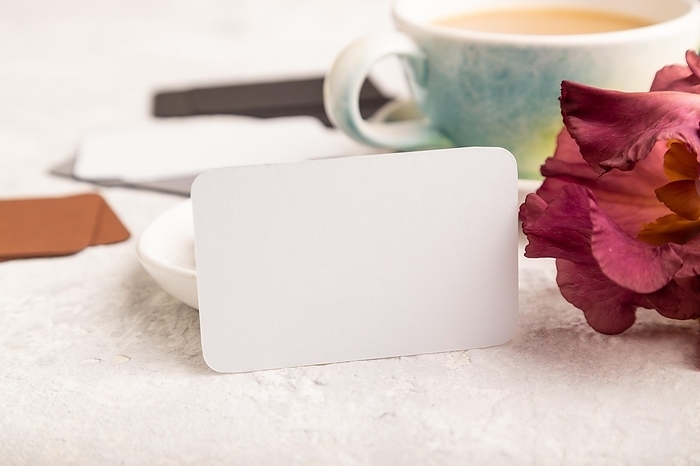White business card with cup of cioffee, chocolate candies and iris flowers on gray concrete background. side view, copy space, still life. Breakfast, morning, spring concept, by ULADZIMIR ZGURSKI