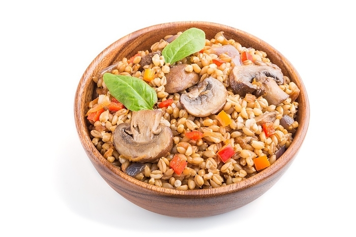 Spelt (dinkel wheat) porridge with vegetables and mushrooms in wooden bowl isolated on white background. Side view, close up. Russian traditional cuisine, by ULADZIMIR ZGURSKI
