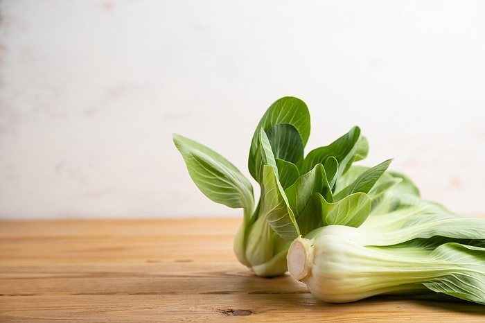 Fresh green bok choy or pac choi chinese cabbage on a brown wooden background. Side view, copy space, selective focus, by ULADZIMIR ZGURSKI