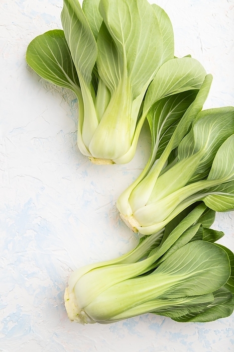 Fresh green bok choy or pac choi chinese cabbage on a white concrete background. Top view, close up, flat lay, by ULADZIMIR ZGURSKI
