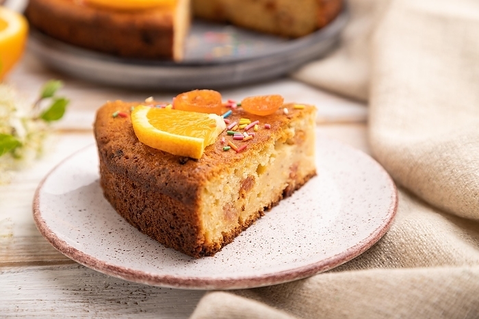 Orange cake and a cup of coffee on a white wooden background and linen textile. Side view, close up, selective focus, by ULADZIMIR ZGURSKI