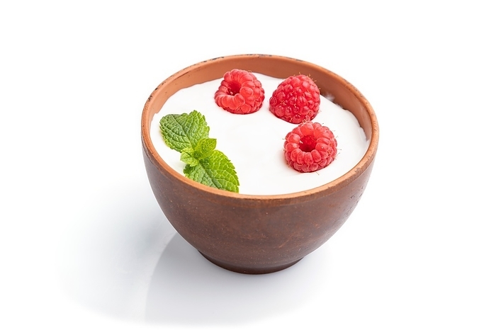 Yogurt with raspberry in clay cup isolated on white background. Side view, close up, by ULADZIMIR ZGURSKI