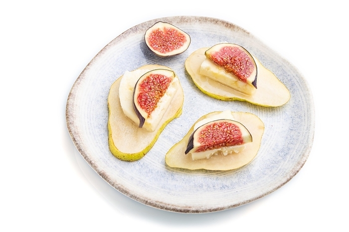Summer appetizer with pear, cottage cheese, figs and honey on ceramic plate isolated on white background. Side view, close up, by ULADZIMIR ZGURSKI
